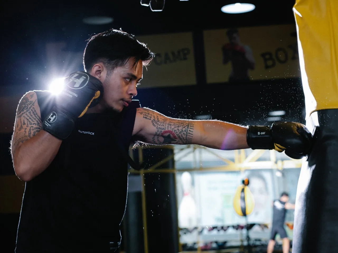 Athlete practising a punch on a heavy bag in a boxing gym